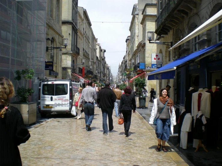 people are walking down a brick road lined with shops