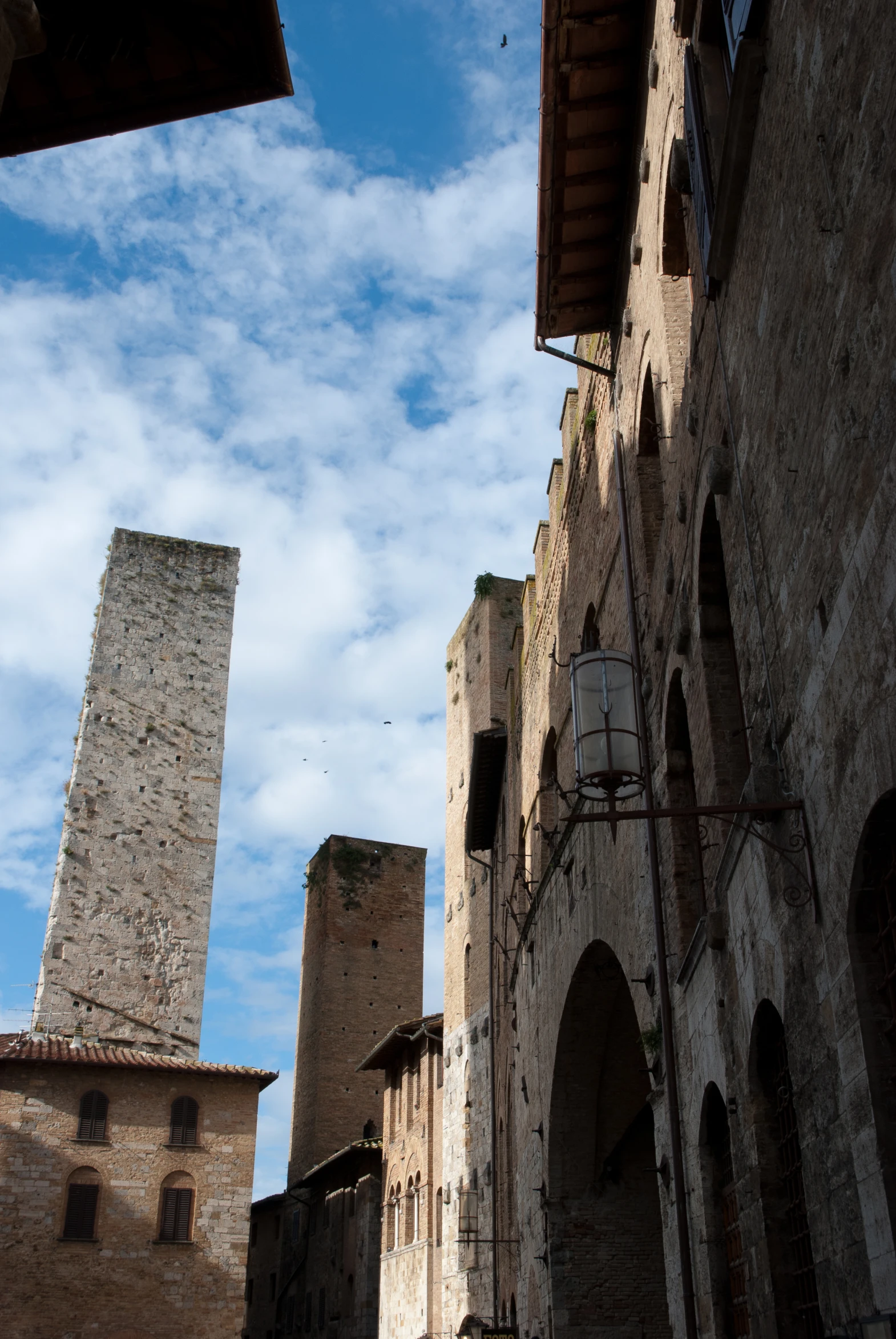 a tall tower rises above some building made from brick