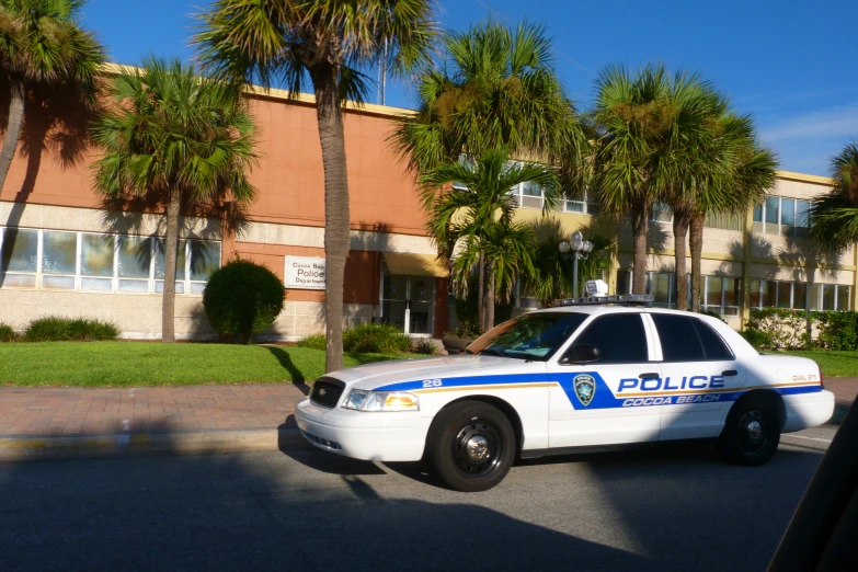 a white police car parked in front of a building