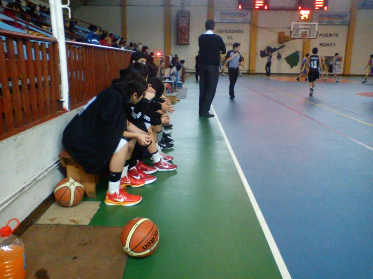 a group of children in orange boots playing basketball