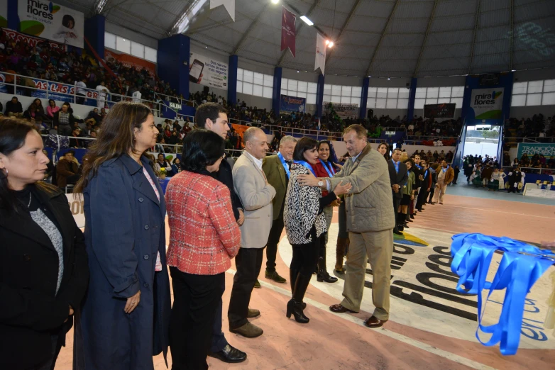 people standing at tables on an arena during a ceremony