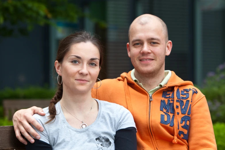 a man and woman who are sitting on a bench