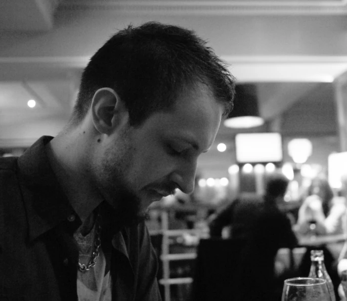 a man at a restaurant with a glass of wine in front of him