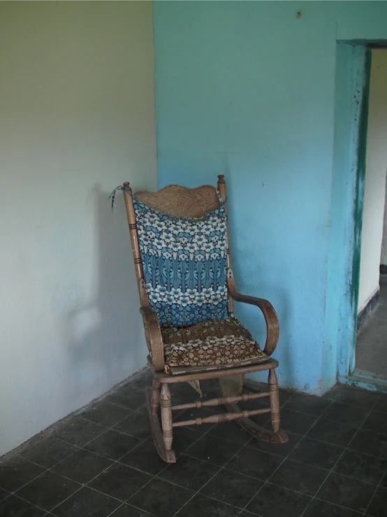 the chair is in front of the wall with a pillow on it