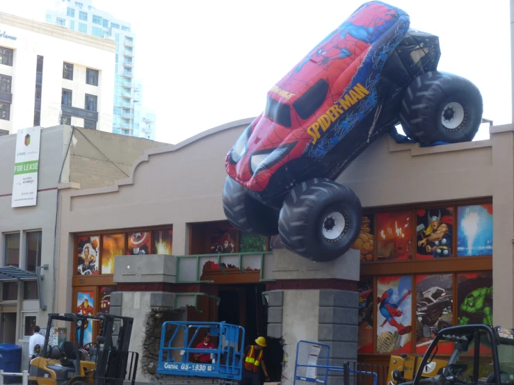 a red car that is in the air near some windows