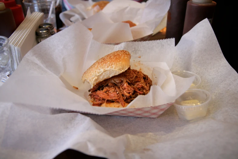 sandwich in white paper basket next to beer