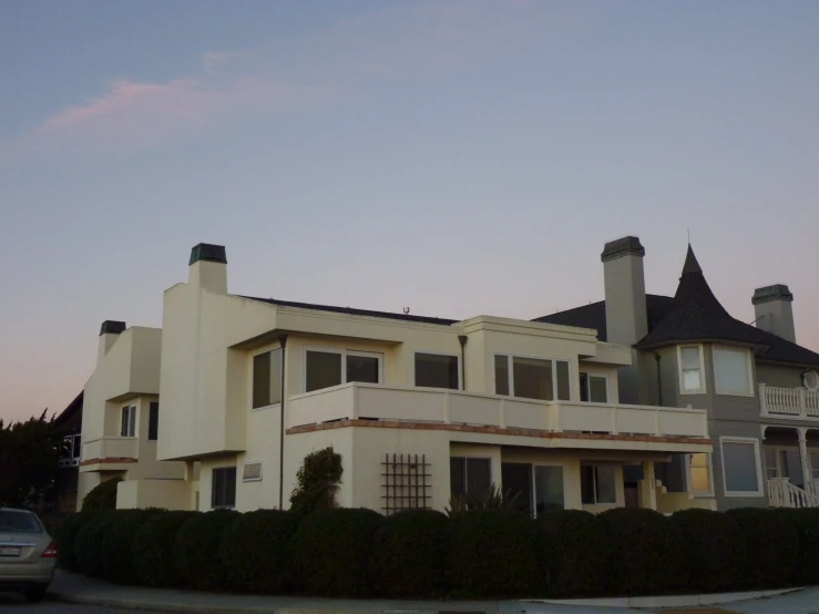 the home at sunset with cars parked in front