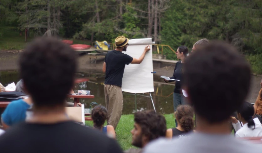 man standing on easel painting people holding an easel