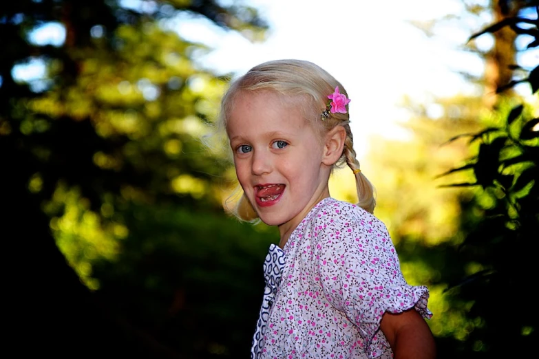 a small girl with blond hair wearing a dress