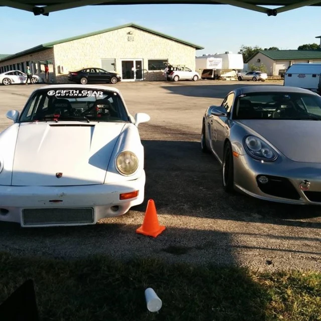 two white sports cars parked side by side in a parking lot