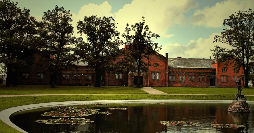 the large building is surrounded by grass and trees