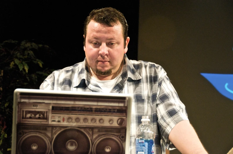 a man sitting down with his hands on a laptop