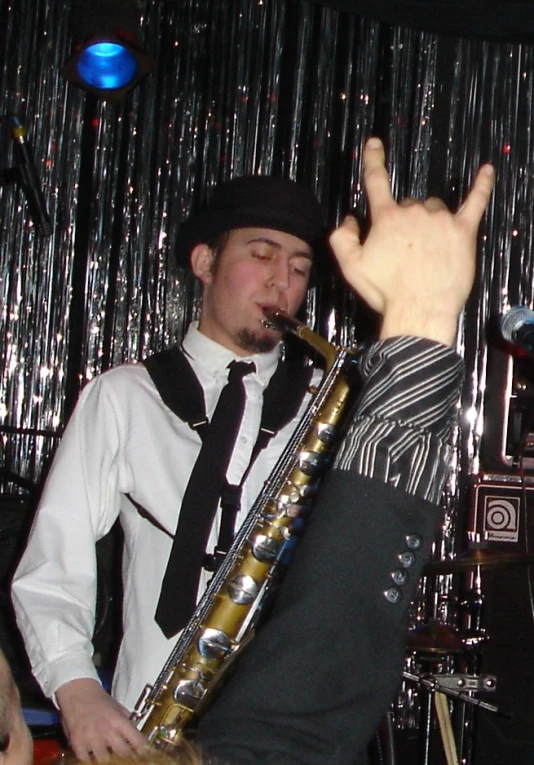 a man wearing a suit and tie playing saxophone