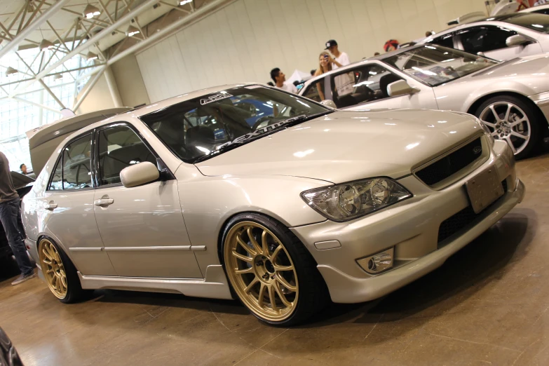 some very pretty modified cars in a big room