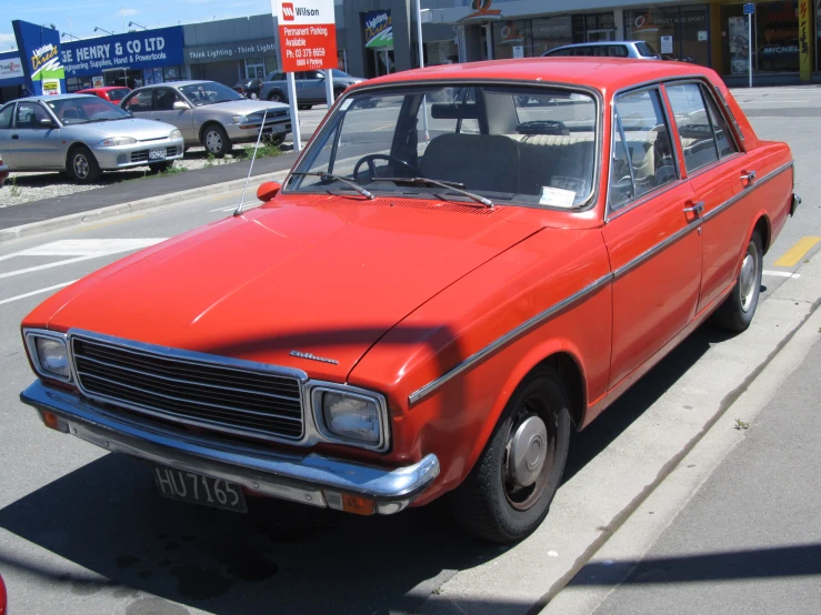 an orange and silver car is parked on the side of the street