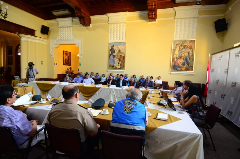 an overview view of people sitting in a large meeting room