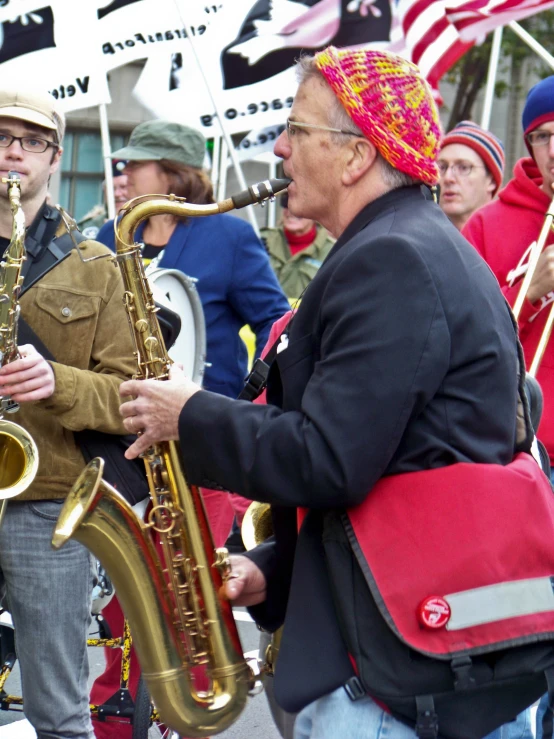 people are gathered on the street to watch an outdoor band