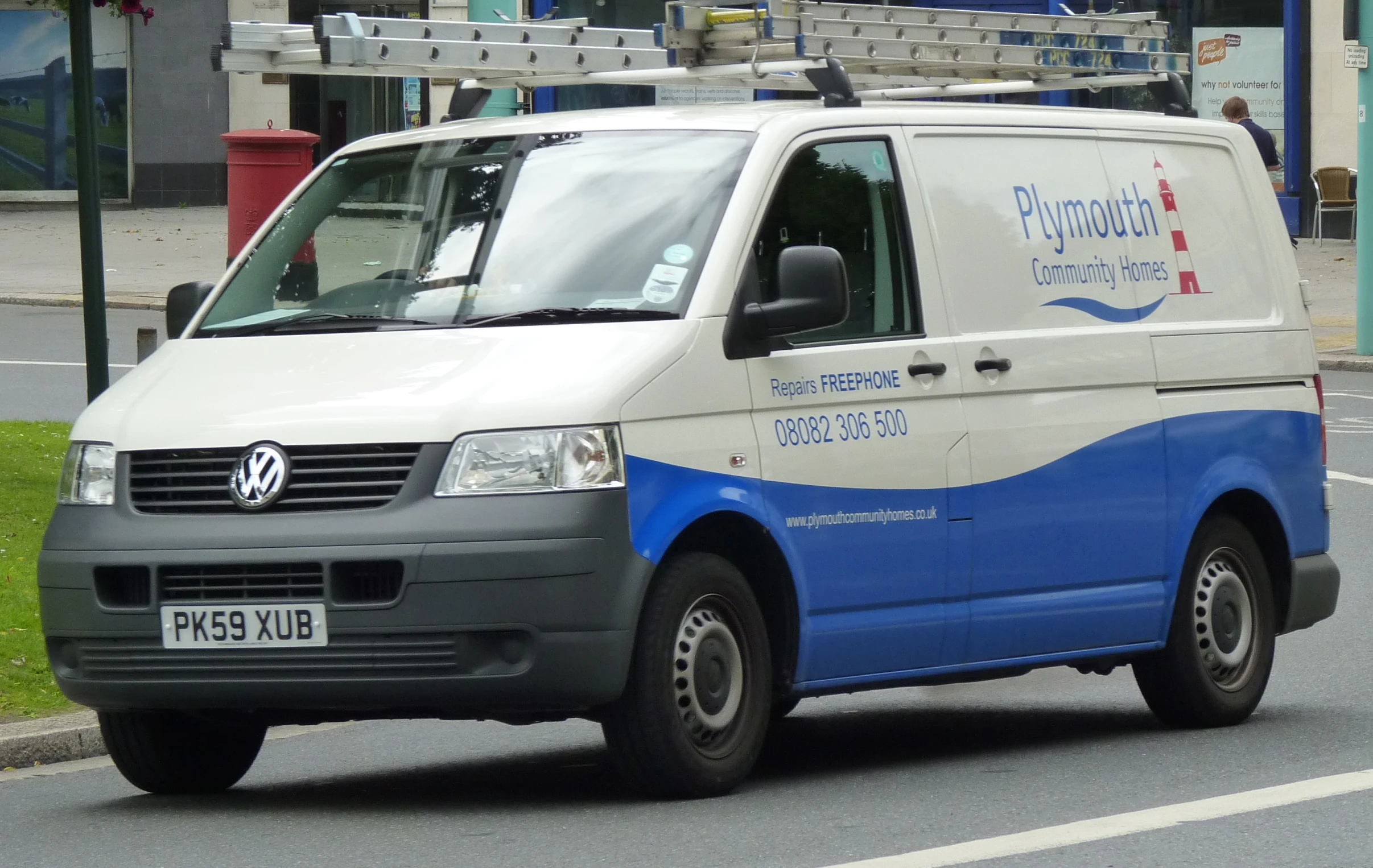 a van is driving on a street next to a blue and white bus