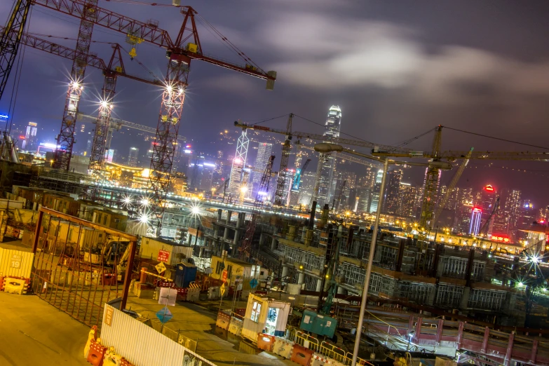 a picture of the city and cranes from across the river