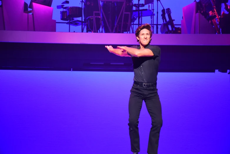 a guy on a skateboard performing in a dark purple room