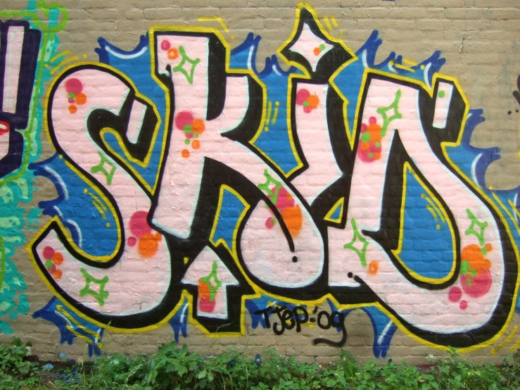 a brick wall covered in colorful graffiti that reads'sasrap '