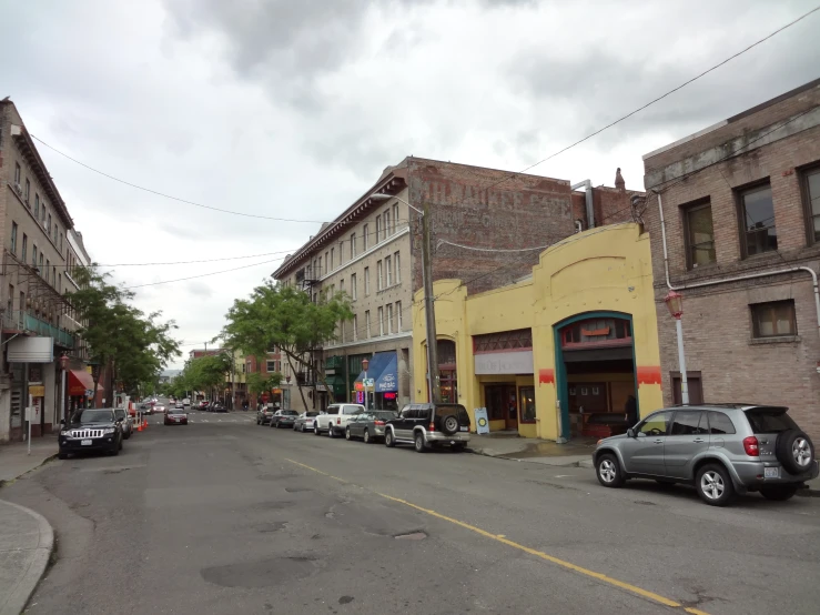 the view down a street with old buildings and parked cars