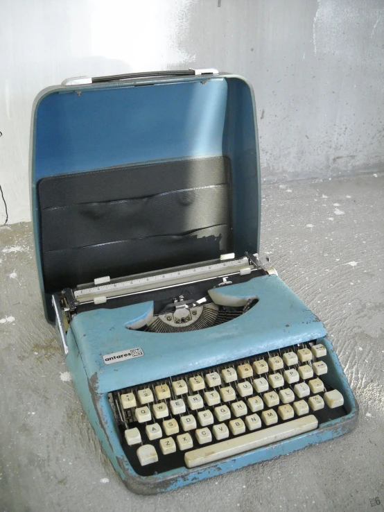 an old blue typewriter with open case