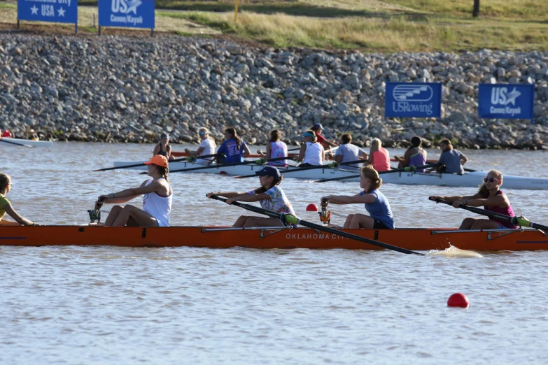 a group of people sitting in their canoes and rowing