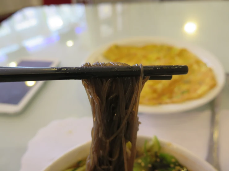 an asian noodle dish with two plates of food