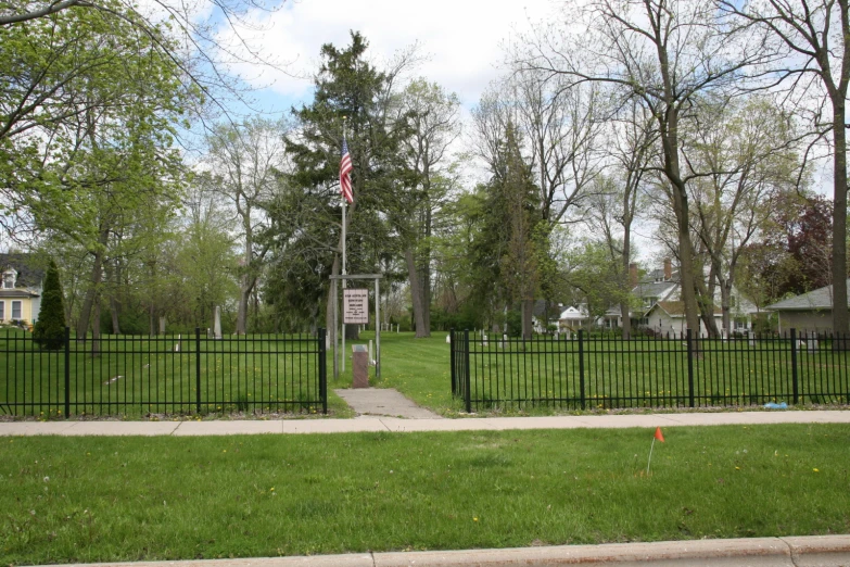 two flags at the top of a hill at a cemetery