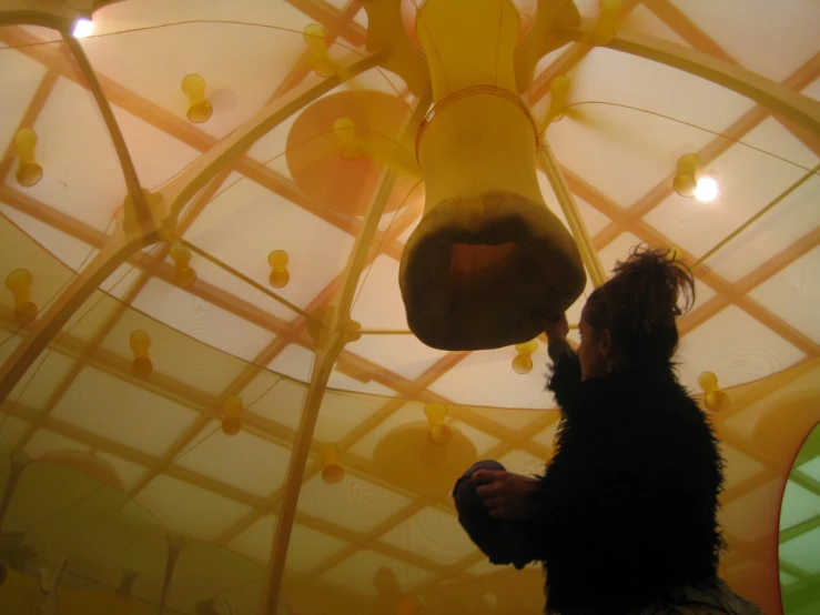a man standing under a ceiling with yellow lights