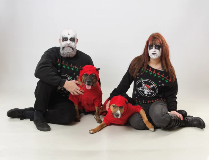 two people in white face masks pose with their dogs