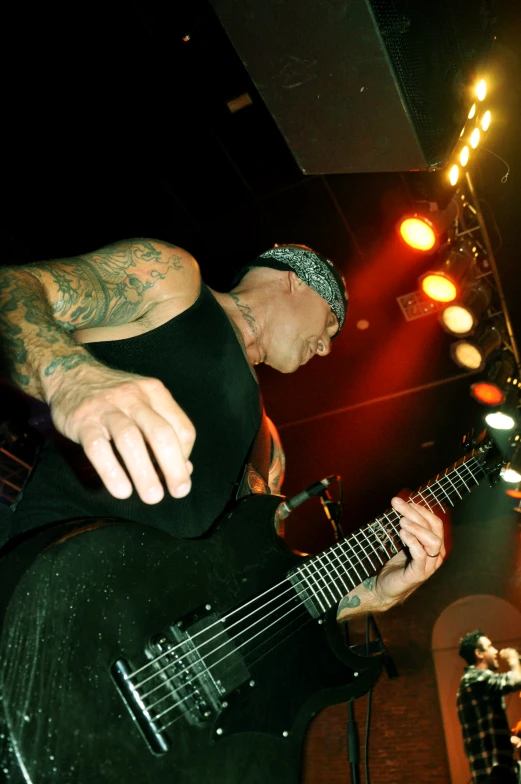 a man with a black shirt on and a guitar