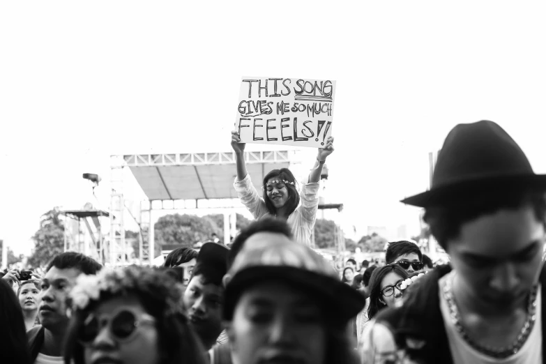 a man in a black fedora holding a sign