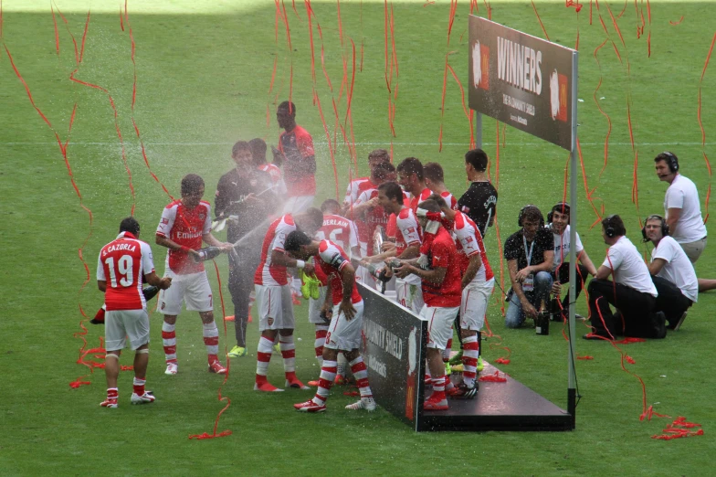 a group of young soccer players spraying water on them