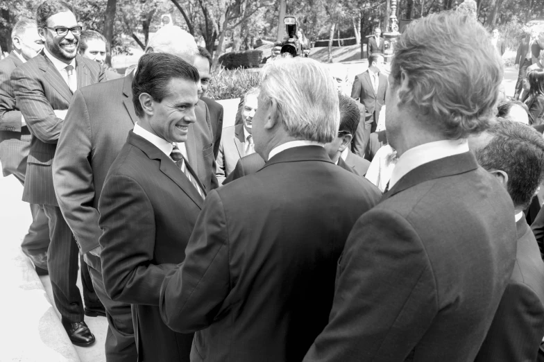 four men in business suits smile for the camera