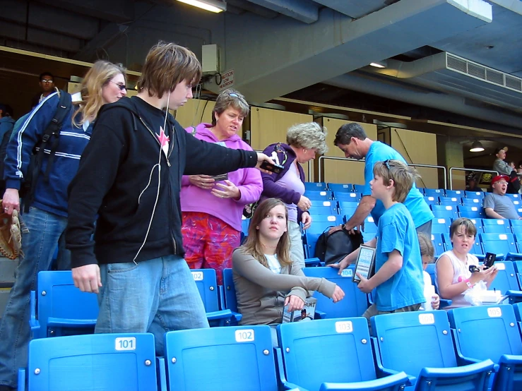 several people standing in a crowd sitting in a stadium