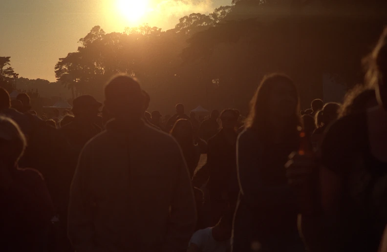 a large crowd is gathered and enjoying the sunset