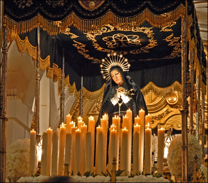 a candle chandelier with a virgin mary surrounded by gold and white candles