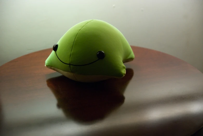a green object sits on a table near the corner of a room