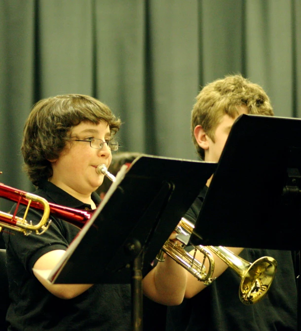 two young men playing musical instruments on stage