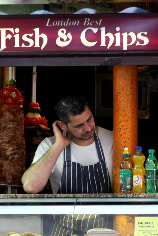 the man is talking on his cellphone by the grill