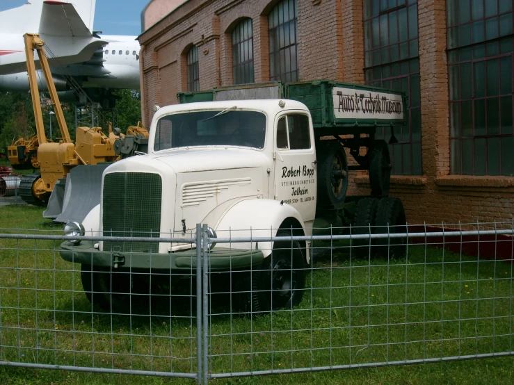 an old tractor parked next to an old truck