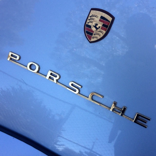 the logo on the hood of a blue porsche