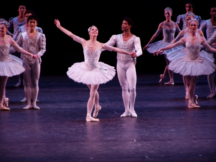 a group of ballet dancers perform on stage