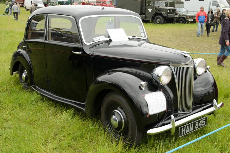 a black old car sits on display at an antique vehicle show
