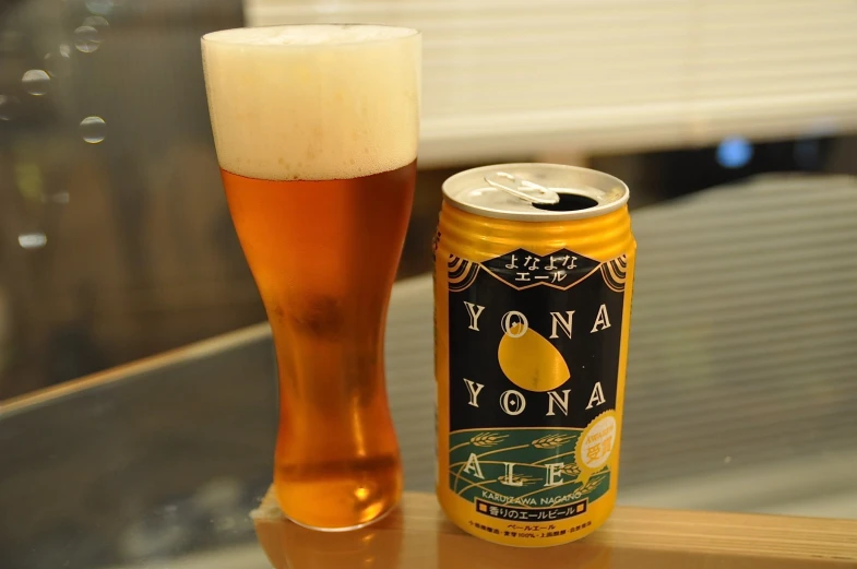 a glass next to a can with beer