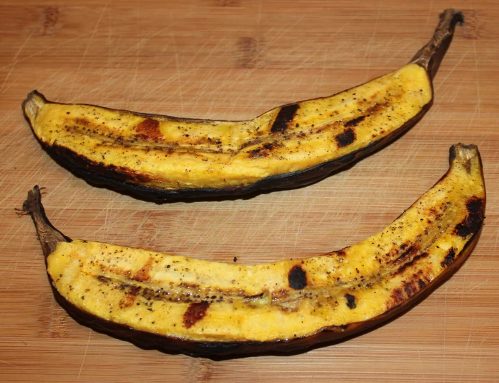 two bananas are yellow with brown spots and black marks