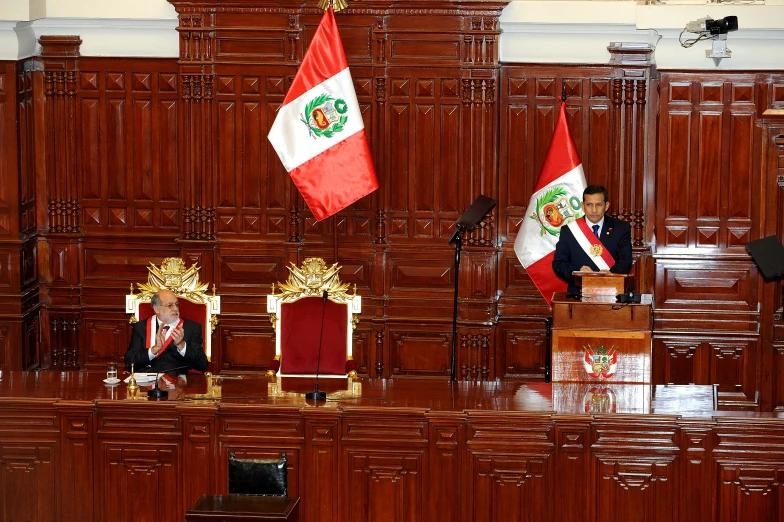 a man at a podium in front of several flags