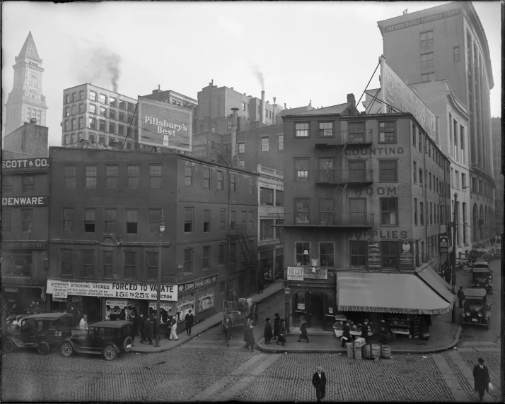 an old po of people gathered at an intersection in a city